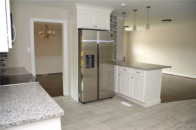 kitchen with white cabinets, pendant lighting, kitchen peninsula, and stainless steel appliances