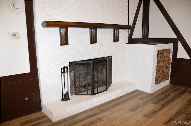 room details featuring wood-type flooring and a brick fireplace