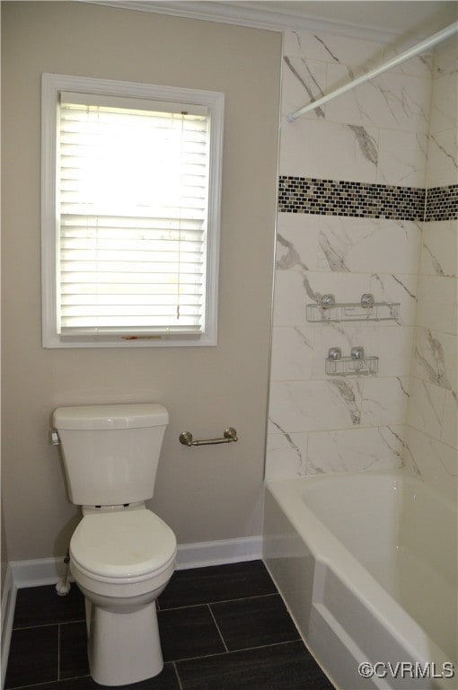 bathroom featuring toilet, ornamental molding, and tiled shower / bath