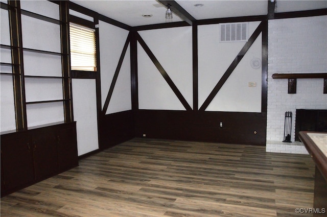 unfurnished living room featuring dark hardwood / wood-style flooring and a brick fireplace