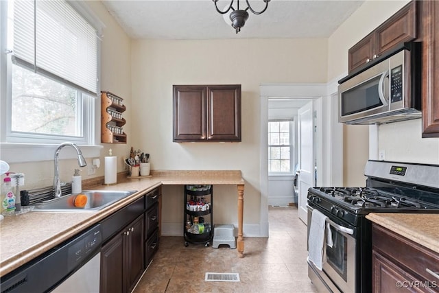 kitchen featuring dark brown cabinets, stainless steel appliances, and sink