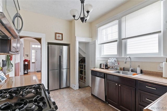 kitchen with hanging light fixtures, sink, stainless steel appliances, and dark brown cabinets