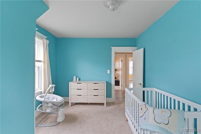 carpeted bedroom with a nursery area