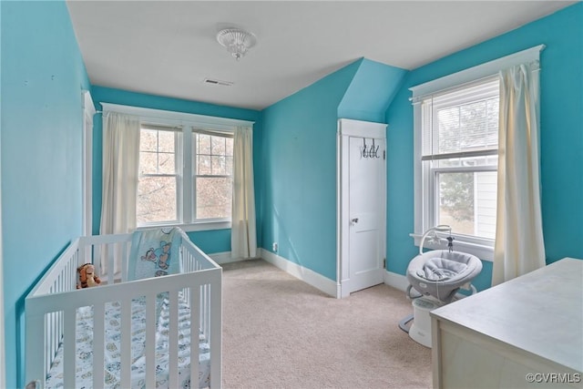 bedroom featuring light colored carpet and a crib