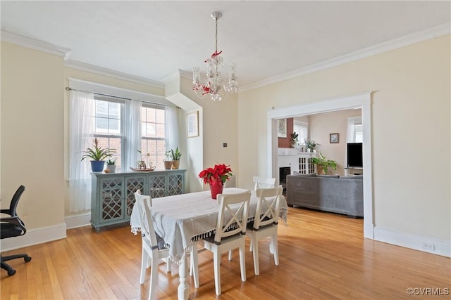 dining room with hardwood / wood-style floors, an inviting chandelier, and ornamental molding