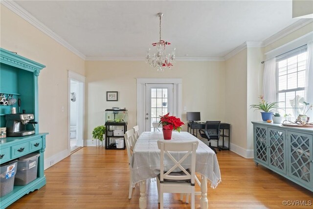 dining space with crown molding, plenty of natural light, a notable chandelier, and light wood-type flooring