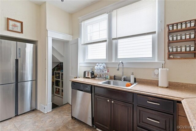 kitchen featuring dark brown cabinets, sink, and appliances with stainless steel finishes