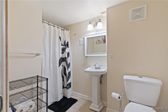 bathroom featuring a shower with curtain, toilet, tile patterned floors, and sink