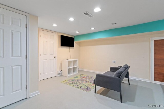 sitting room with a baseboard heating unit and concrete floors