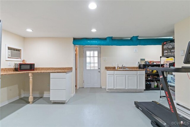 kitchen featuring sink, white cabinets, and a wall mounted air conditioner