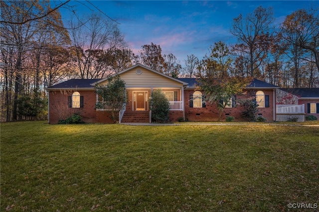 ranch-style house featuring a porch and a lawn