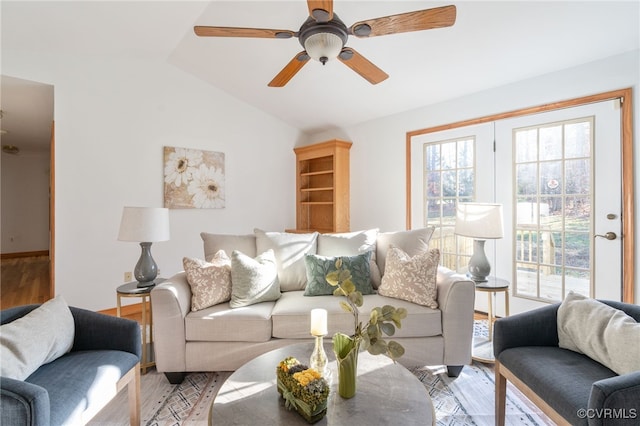 living room featuring a wealth of natural light, ceiling fan, lofted ceiling, and light wood-type flooring