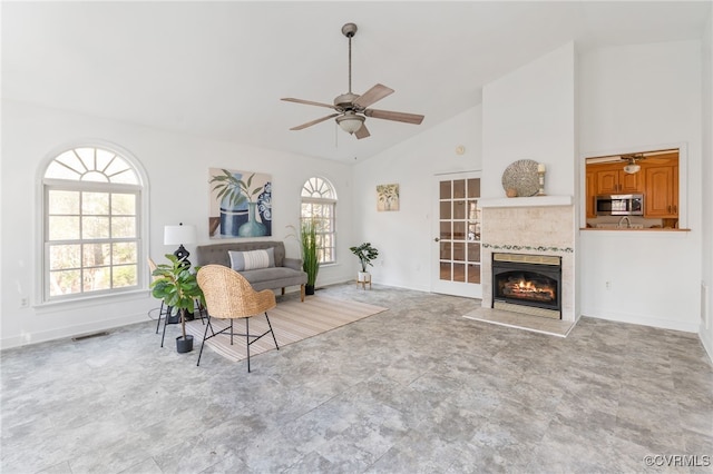 living room with ceiling fan, a fireplace, and high vaulted ceiling