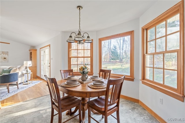 dining room with vaulted ceiling, light hardwood / wood-style flooring, and an inviting chandelier