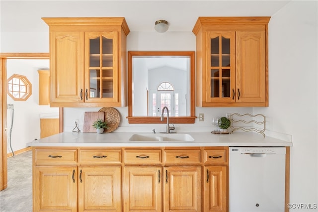 kitchen with light brown cabinetry, dishwasher, lofted ceiling, and sink