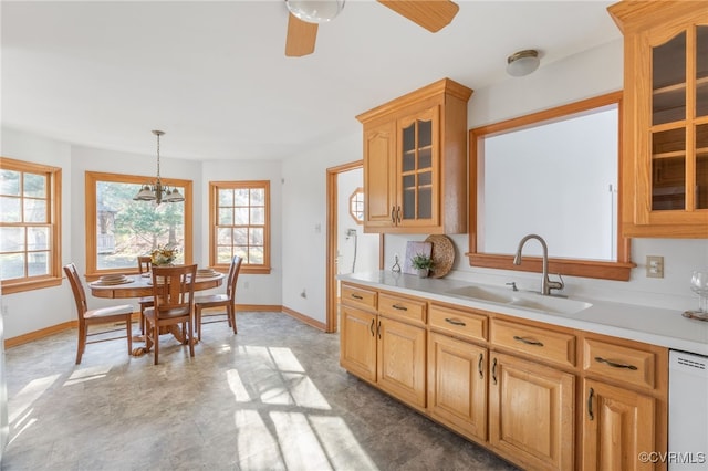 kitchen featuring sink, white dishwasher, a healthy amount of sunlight, and decorative light fixtures