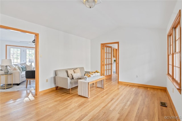 living area featuring light hardwood / wood-style flooring, ceiling fan, and lofted ceiling