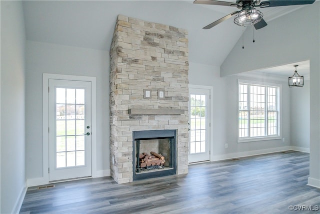 unfurnished living room featuring a wealth of natural light, a fireplace, and dark hardwood / wood-style floors