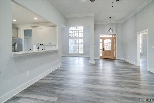 foyer entrance with dark hardwood / wood-style floors, ceiling fan, and crown molding