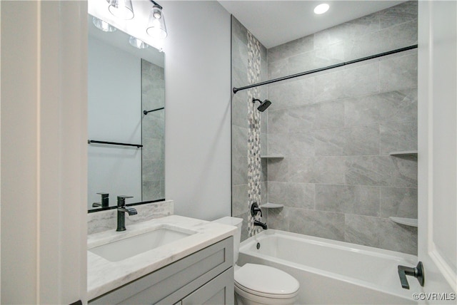 full bathroom with vanity, tiled shower / bath, and toilet