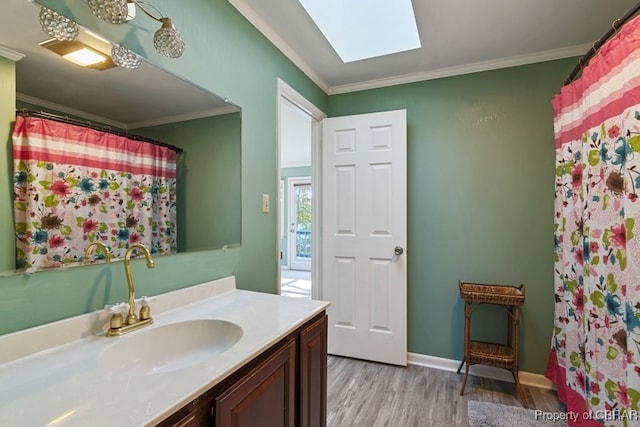 bathroom featuring a skylight, a shower with curtain, wood-type flooring, vanity, and ornamental molding