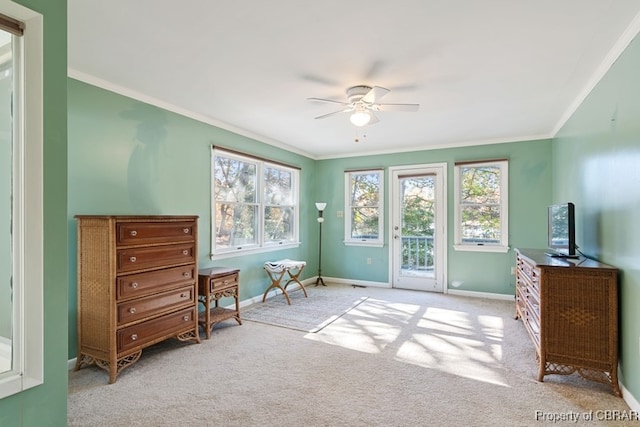 sitting room featuring a wealth of natural light, crown molding, ceiling fan, and light colored carpet