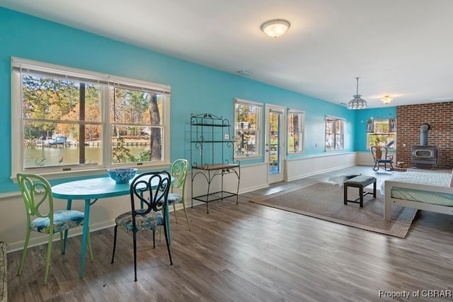 dining area featuring a wood stove and dark wood-type flooring