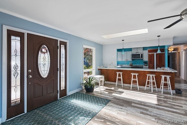 foyer with dark hardwood / wood-style flooring, ornamental molding, and a wealth of natural light