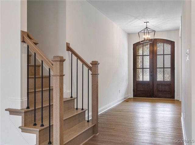 foyer entrance featuring a chandelier, light wood-type flooring, and french doors