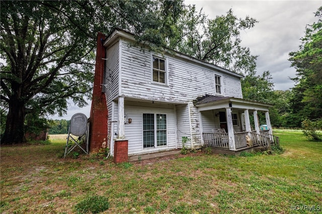 back of property featuring a porch and a lawn