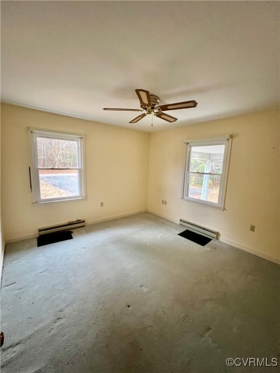 empty room with carpet flooring, ceiling fan, a wealth of natural light, and a baseboard radiator