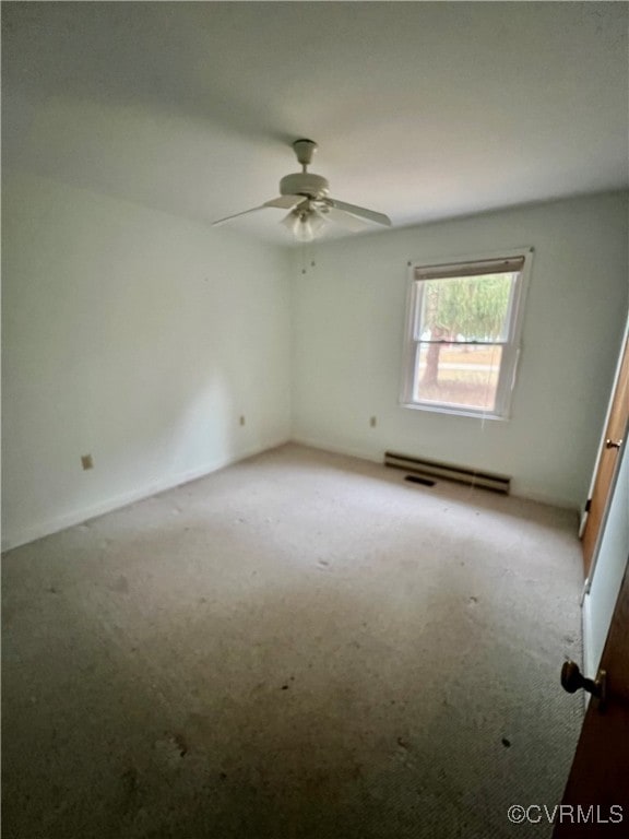 carpeted spare room with ceiling fan and a baseboard heating unit