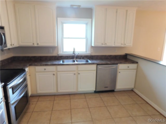 kitchen featuring white cabinetry, sink, light tile patterned floors, and appliances with stainless steel finishes