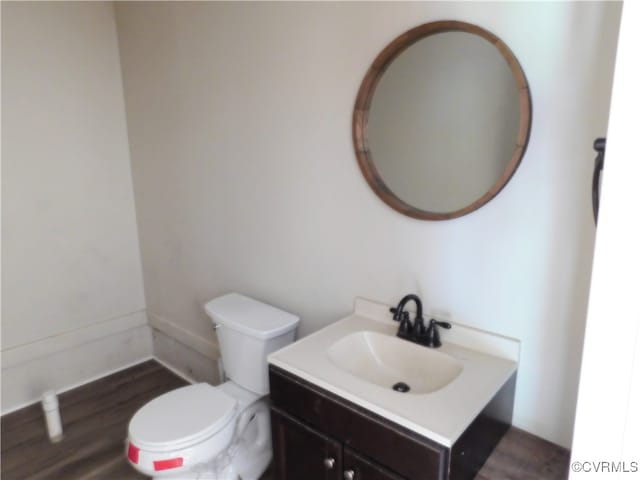 bathroom with hardwood / wood-style flooring, vanity, and toilet