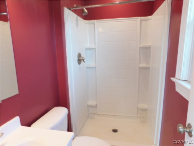 bathroom with tiled shower and toilet