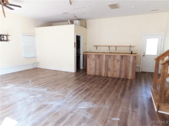 unfurnished living room featuring ceiling fan and dark wood-type flooring