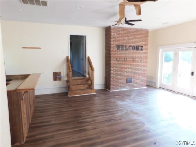 unfurnished living room with ceiling fan and dark wood-type flooring