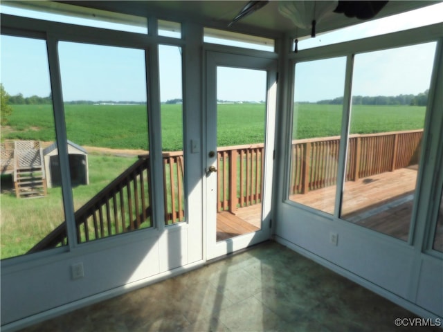 unfurnished sunroom featuring a rural view