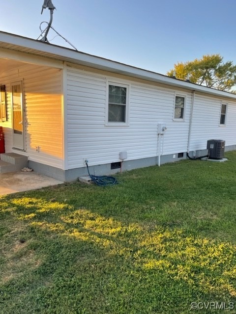 view of property exterior featuring central air condition unit and a yard