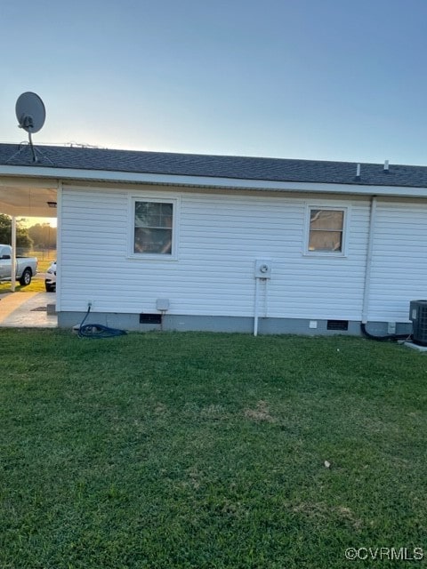 view of property exterior with a lawn and central AC unit