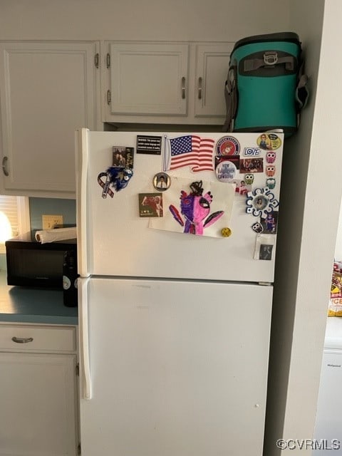 kitchen featuring white cabinetry and white refrigerator