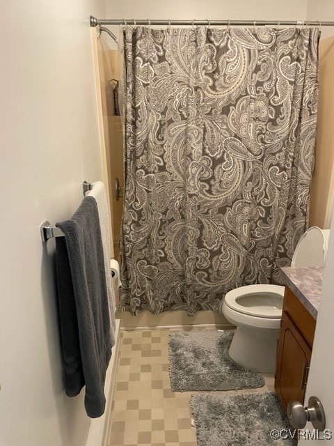 bathroom featuring curtained shower, vanity, and toilet