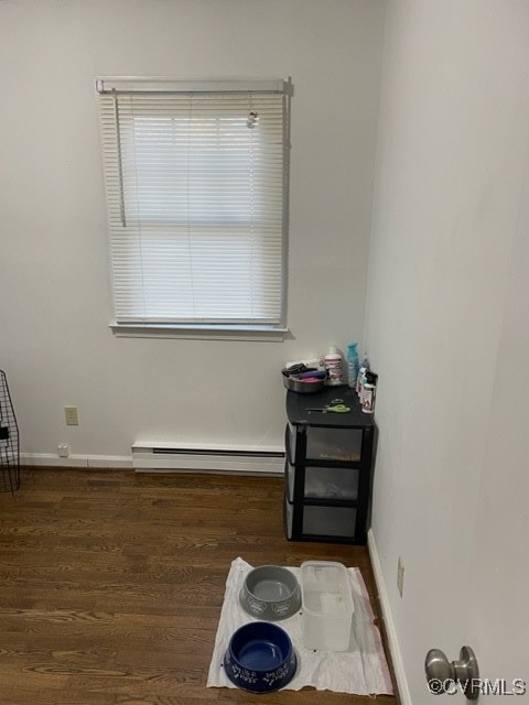 empty room with a baseboard radiator and dark hardwood / wood-style floors