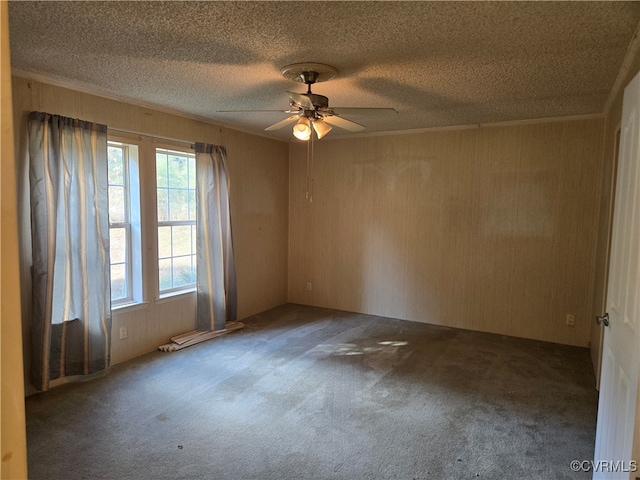 empty room featuring carpet, ceiling fan, ornamental molding, and a textured ceiling