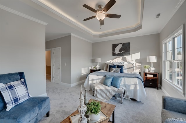 carpeted bedroom with ceiling fan, a raised ceiling, and crown molding