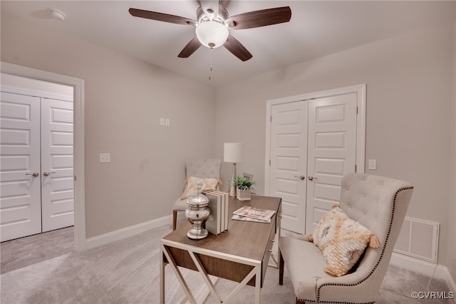 living area with light colored carpet and ceiling fan