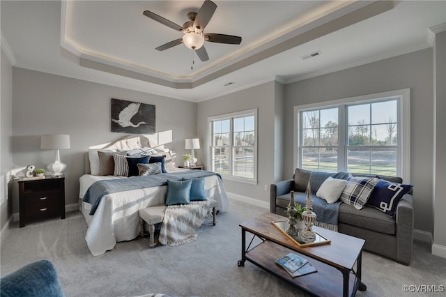 bedroom with a tray ceiling, ceiling fan, light colored carpet, and ornamental molding