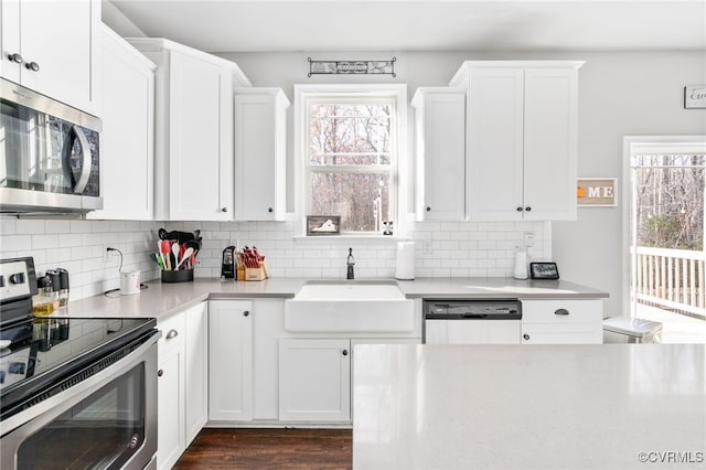 kitchen featuring appliances with stainless steel finishes, dark hardwood / wood-style flooring, backsplash, sink, and white cabinets