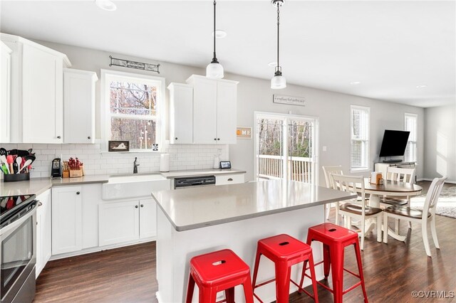 kitchen with pendant lighting, dark hardwood / wood-style flooring, white cabinetry, and a kitchen island