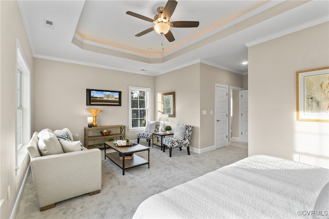 bedroom featuring a raised ceiling, light carpet, crown molding, and ceiling fan